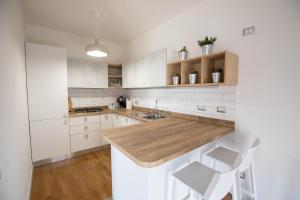 eine Küche mit weißen Schränken und einer hölzernen Arbeitsplatte in der Unterkunft Bay View Apartment in Porto Torres