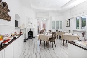 una cucina e una sala da pranzo con pareti bianche e pavimenti in legno di Vittoria Colonna Luxury B&B a Ischia