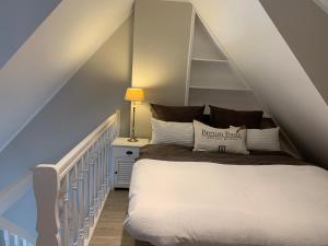 a bedroom with a white bed in the attic at Keitum - hochwertig und gemütlich Wohnen unter Reet in Keitum