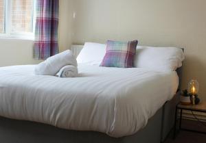 a bed with white sheets and pillows and a window at Luke stays - Cheveley Park in Durham