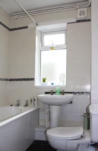 baño con lavabo y aseo y ventana en Luke stays - Cheveley Park en Durham