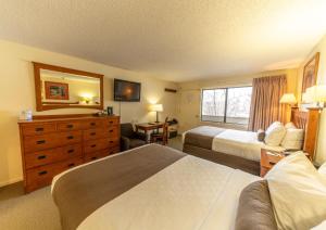 a hotel room with two beds and a television at Pokolodi Lodge in Snowmass Village