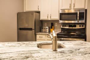 a kitchen with a sink and a stainless steel refrigerator at The Cove of Lake Geneva in Lake Geneva