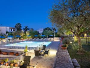 een zwembad met tafels en stoelen naast een resort bij Hotel Colle Del Sole in Alberobello