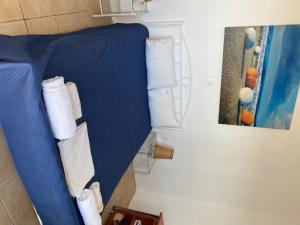 ein blaues Bett im Bad mit Handtüchern in der Unterkunft Kionia Apartments in Kerames