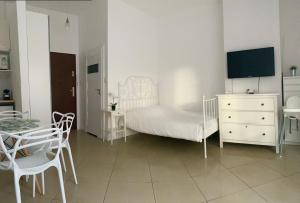 a white bedroom with a bed and a table and chairs at Apartament Villa Marea 22 in Międzyzdroje
