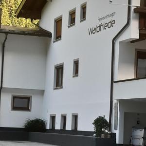 a white building with a sign on the side of it at Haus Waldfriede in Sankt Leonhard im Pitztal