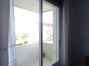 a sliding glass door with a view of a balcony at La Casa de Vicenta in Arzúa