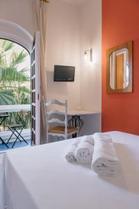 a bedroom with a bed with a chair and a television at Mami Sabaudia Hotel in Sabaudia
