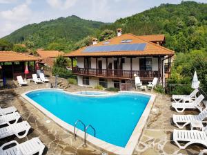 eine Villa mit einem Pool vor einem Haus in der Unterkunft Family Hotel Chiflik Hills in Chiflik