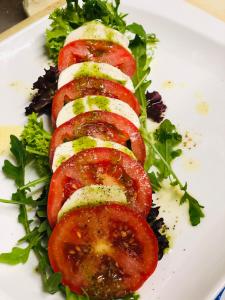 un plato de comida con tomates y verduras. en Hotel Restaurant Borchard, en Lübbecke