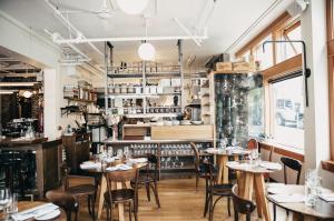 um restaurante com mesas e cadeiras num quarto em Victorian Hotel em Vancouver