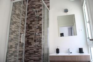 a bathroom with a shower with a sink and a mirror at The Cathedral Rooms in Málaga