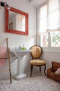 a bathroom with a sink and a chair and a mirror at Villa colonial Jardin Algorta centro Puerto Viejo in Getxo