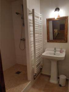 La salle de bains blanche est pourvue d'un lavabo et d'un miroir. dans l'établissement Château de Cauderoue, à Nérac