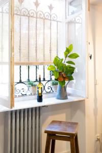 a window sill with a table and a vase with a plant at Villa colonial Jardin Algorta centro Puerto Viejo in Getxo