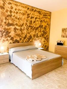 a bedroom with a large bed with a wooden headboard at Casa Di Caro in Naro