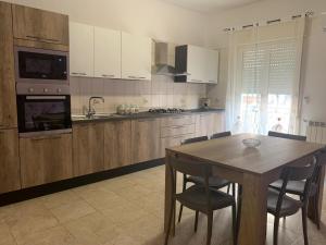 a kitchen with a wooden table and a table and chairs at Casa Di Caro in Naro