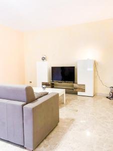 a living room with a couch and a flat screen tv at Casa Di Caro in Naro