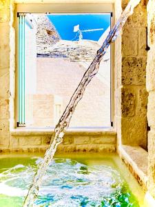 a water hose coming out of a building with a window at Trulli Antichi Mestieri - Widespread Trulli in the historic center in Alberobello