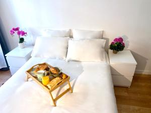 bandeja de comida en una cama con sábanas blancas en Oasis au Coeur de Ville, en Le Plessis-Robinson