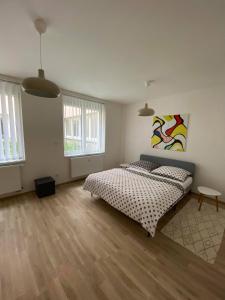 a bedroom with two beds and a painting on the wall at Apartmán OKO in Písek