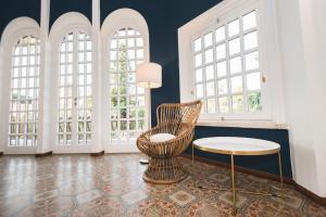 a room with a chair and a table and windows at Mami Sabaudia Hotel in Sabaudia