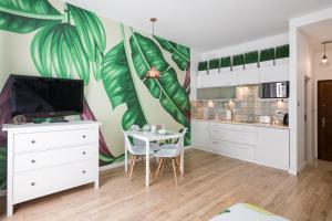 a kitchen with a large mural of leaves on the wall at Cozy modern STUDIO GREEN APARTMENT in Old Town in Krakow