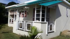 una casa blanca con toldo azul en Villa Anse Goeland, en Rodrigues Island