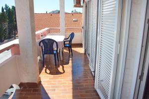 a patio with a table and chairs on a balcony at Apartmani Vidušin in Novalja