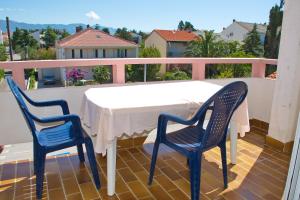 a table and two chairs on a balcony at Apartmani Vidušin in Novalja