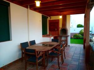 een keuken met een houten tafel en stoelen op een terras bij Ocean & Fire in Playa Blanca