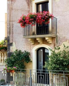 un edificio con 2 balcones con flores en B&B Santapau Charme Living, en Licodia Eubea