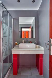 y baño con lavabo blanco y espejo. en Castello Di Cavallieri Suites & Spa - Adults Only en Faliraki