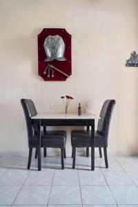 a dining room table with two chairs and a plate on the wall at Castello Di Cavallieri Suites & Spa - Adults Only in Faliraki