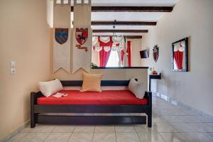 a red bench in a room with a window at Castello Di Cavallieri Suites & Spa - Adults Only in Faliraki