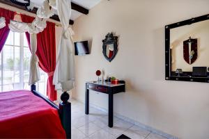a bedroom with a bed and a mirror and a table at Castello Di Cavallieri Suites & Spa - Adults Only in Faliraki