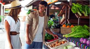 a man and a woman standing in front of a produce stand at 330 - Edf Aguamarina - Vacation Rental Home in the coast line of Golf del Sur in San Miguel de Abona