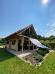 a house with a large white tent in front of it at Loghouse Brunka - Escape from life on a highway in Gornja Radgona