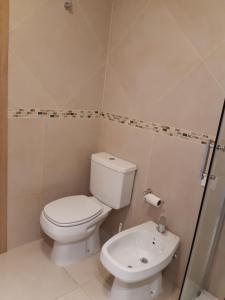 een badkamer met een wit toilet en een wastafel bij La Esquina in San Martín de los Andes