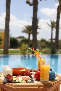 a table with a tray of food and a glass of orange juice at Dar El Jerbi in Mezraya