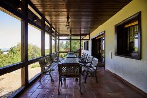 a screened in porch with a table and chairs at Villa Szalamandra - az Erdőszéle in Matraalmas