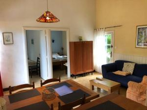 a living room with a blue couch and a table at L'étang des Mirandes in Varaignes