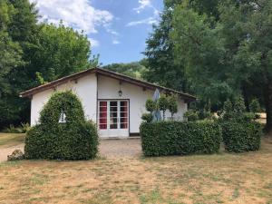 a small white house with a red door at L'étang des Mirandes in Varaignes