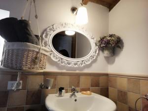 bagno con lavandino e specchio a parete di Il Palazzetto sulla Francigena a Formello