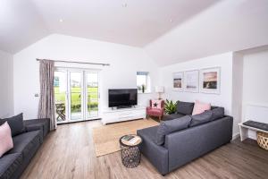 a living room with two couches and a tv at Footsteps to the beach, Seaviews & Beautiful Sunsets in Westward Ho