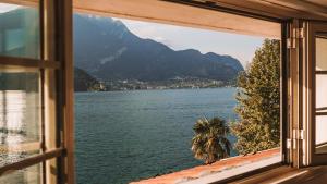 a window with a view of a lake and mountains at Casa Zoe in Lezzeno
