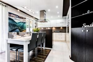 a kitchen with a white table and black cabinets at Apartament MAJA 13 in Zakopane