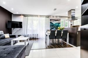 a kitchen and living room with a couch and a table at Apartament MAJA 13 in Zakopane