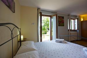 um quarto com uma cama e uma grande janela em Casetta dei LuPi em Miazzina